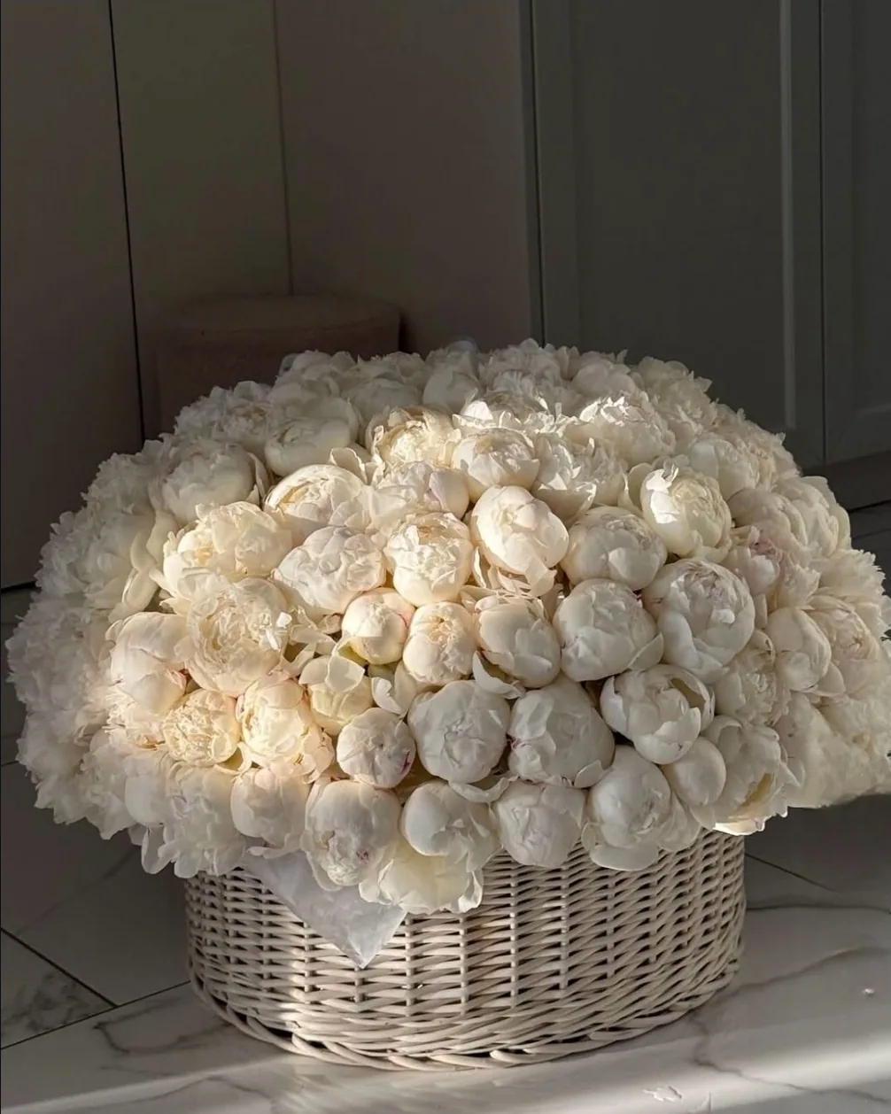 A large arrangement of white roses in a basket