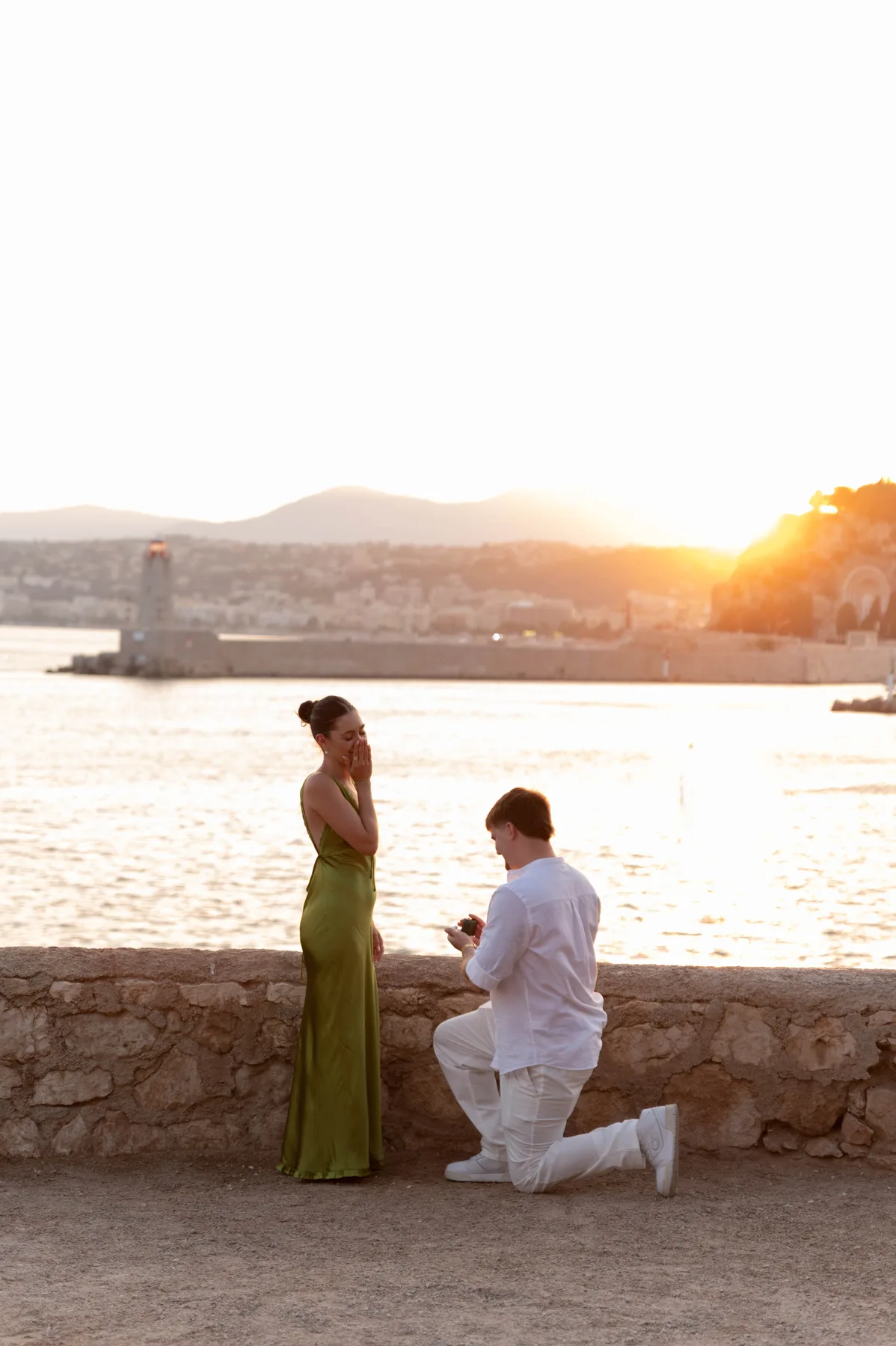 A man on one knee proposing at sunset above the sea in Nice